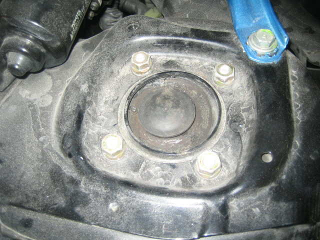 Først løsnet vi den ene bolten under gummidekselet og deretter ble de fire muttere synlig på bildet løsnet