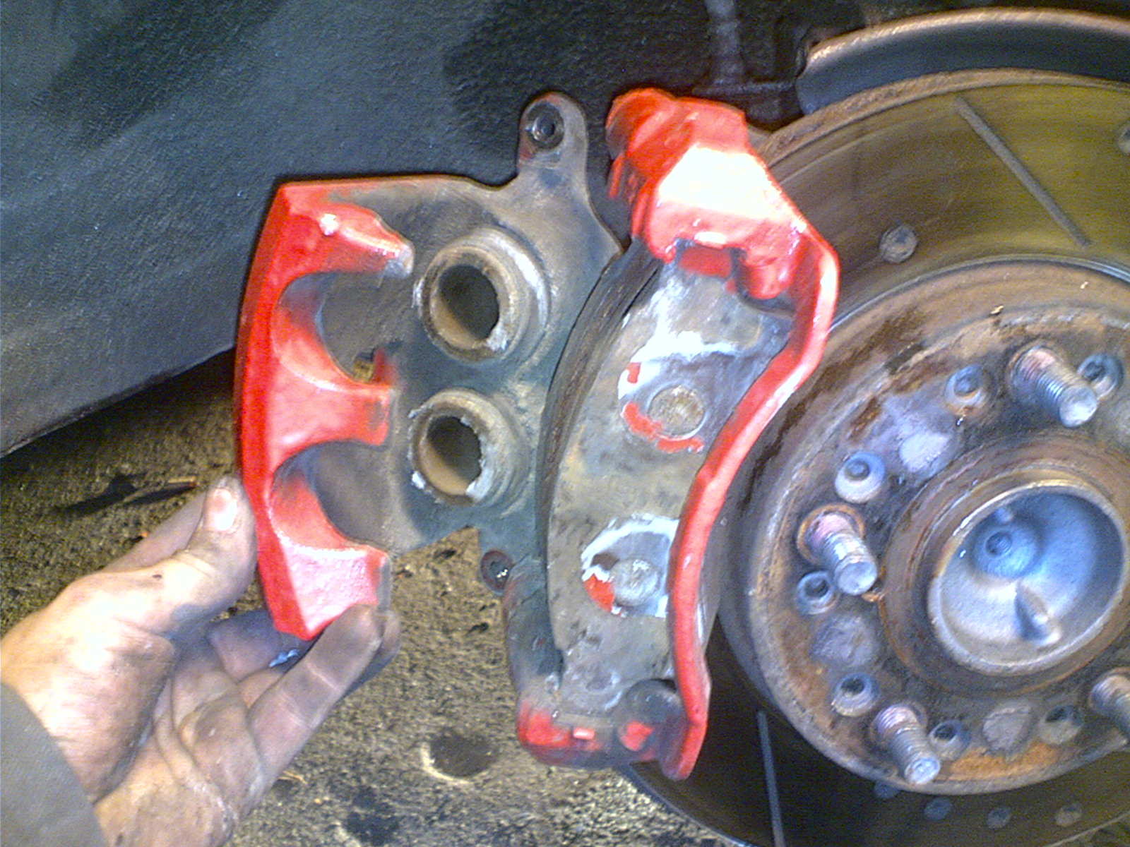 2. Løsne de to boltene i bak-kant som gliderene sitter festet i, dette er hva som holder den på plass. To tre omdreininger med en nøkkel, så kan du skru dem ut med fingrene. Ta dem helt ut og du kan ta vekk hele denne delen.